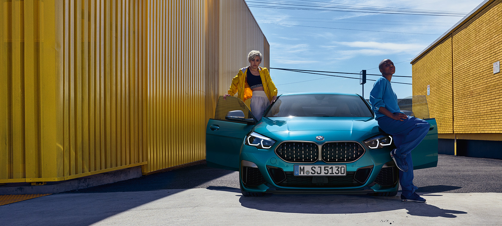 BMW 2 Series Gran Coupé F44 Snapper Rocks Blue, front view with open doors and two people at the vehicle